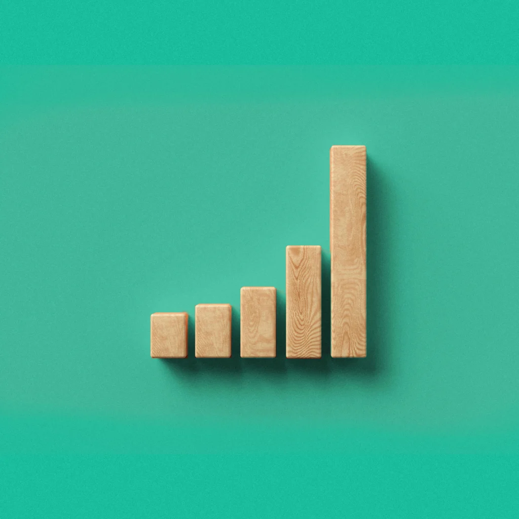 Wood blocks in an upward moving graph on a mint green background.