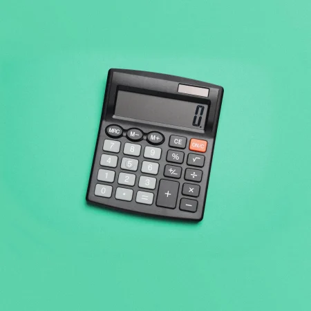 Calculator on a mint green background.