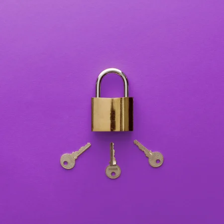 Three keys pointing to the keyhole on a padlock on purple background.